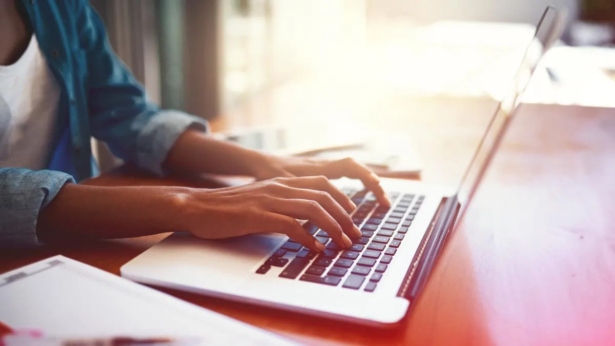 Person filling out a product requirements document template on a laptop.